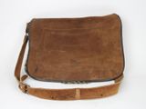 un vieux sac en cuir marron muni d'une bandoulière, sur fond blanc