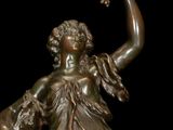 bronze statue of a woman holding a bird and a dog