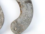 a metal hook with a hole in it on a white surface