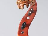 a close up of a violin with a wooden head on it