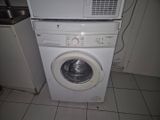 une photo d'une machine à laver blanche dans une cuisine