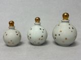 trois petites bouteilles blanches ornées d'étoiles dorées