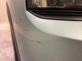 a close up of a car ' s front bumper with scratches on it
