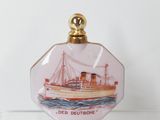 une petite bouteille en verre sur laquelle est représenté un bateau