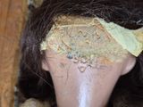 a close up of a head of a doll with a piece of fabric on it