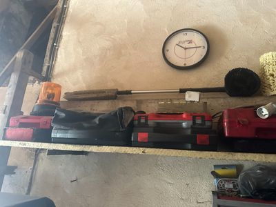 une horloge accrochée au mur, à côté des outils posés sur une étagère