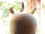 a vase sitting on a window sill next to a pot