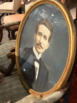 portrait d'un homme en smoking, assis sur une chaise dans une pièce