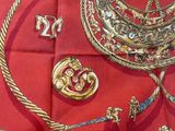 a red table cloth with gold and silver jewelry on it