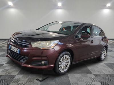 la voiture rouge est garée sur un sol en damier dans le garage