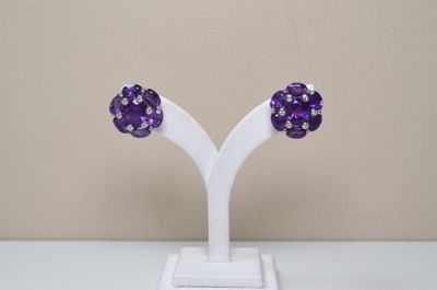 pair of purple crystal earrings on a white stand on a table