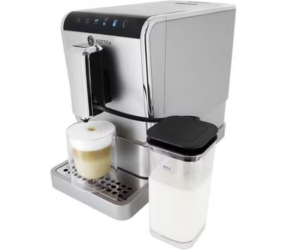a close up of a coffee machine with a cup of milk