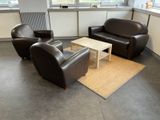 three leather chairs and a coffee table in a room