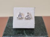 a close up of a pair of silver earrings on a marble block