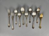 six silver spoons and two silver spoons on a gray surface