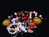 a pile of assorted beads on a black surface