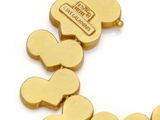 an image of a gold bracelet with four hearts and a tag on it