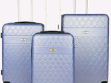 trois valises bleues posées sur un sol blanc