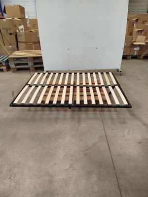 Le cadre du lit est en bois et comporte une armature métallique.
