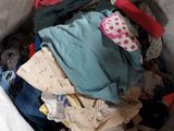 a pile of clothes in a bin on the floor