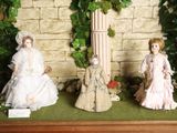 three dolls that are on display in a display case