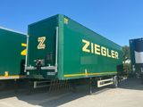 two green semi trucks parked next to each other