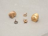 a gold earring and a gold earring on a table