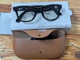 sunglasses in a case sitting on a wooden table with a box