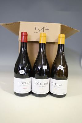 three bottles of wine are in a cardboard box on a table
