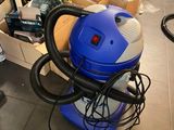 un aspirateur posé sur le sol d'une pièce
