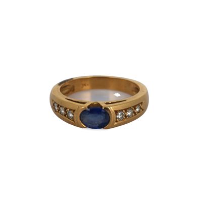 a close up of a gold ring with a blue stone and diamonds