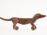 jouet en bois représentant un chien muni de roues, sur fond blanc