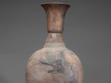 an old vase with a wooden stand on a gray background