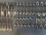 de nombreuses fourchettes et cuillères disposées sur la table