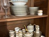 de nombreuses assiettes et tasses rangées sur une étagère dans un placard