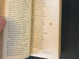 someone is holding a book open to a page with writing on it