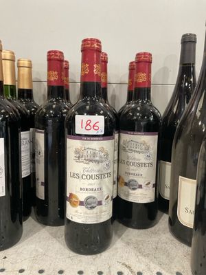 several bottles of red wine are lined up on a counter