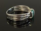 a close up of a ring with a green stone on it