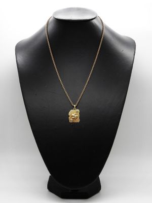 un mannequin noir portant un collier en or