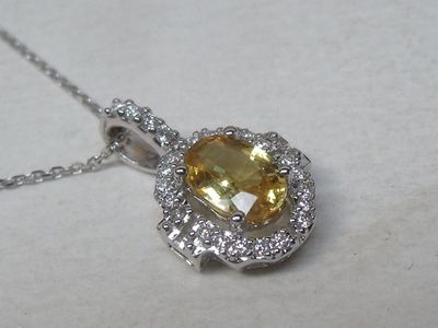 pendentif en saphir jaune et diamants, monté sur une chaîne, sur un fond blanc