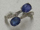 une paire de boucles d'oreilles en saphir bleu et diamants sur un fond blanc