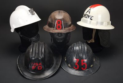 trois casques de chantier portant des numéros, posés les uns à côté des autres