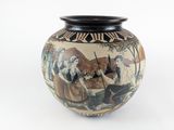 un vase avec un tableau posé sur une table