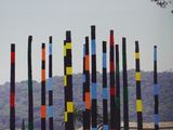 brightly colored poles in a field of wildflowers in front of a tree