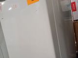 a white refrigerator sitting in a room with boxes on the floor