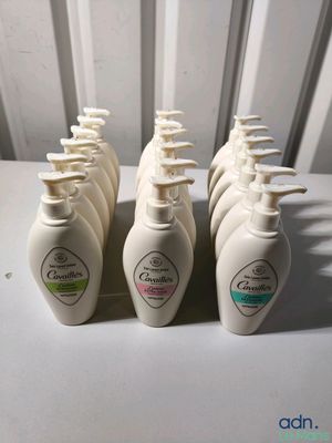 six flacons de gel hydroalcoolique posés sur une table blanche