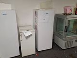 three refrigerators and a freezer in a room