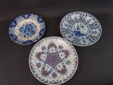 trois assiettes bleues et blanches ornées de motifs floraux, posées sur une table