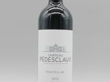 une bouteille de vin rouge posée sur une table blanche