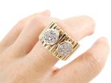 a woman ' s hand holding a gold and diamond ring